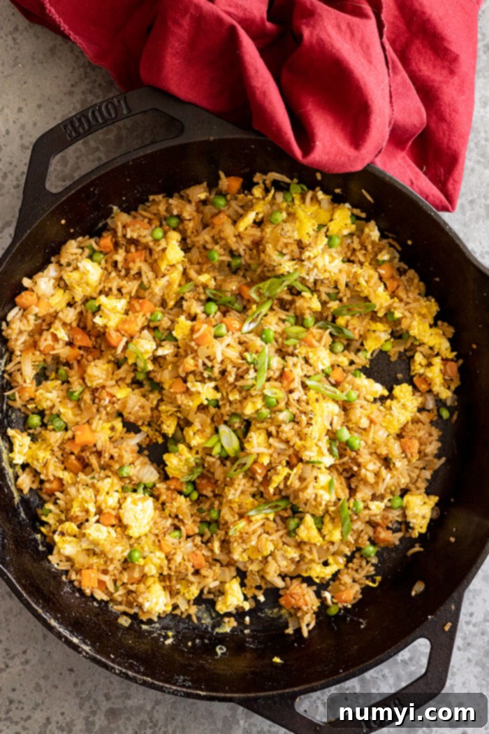 Overhead of rice freshly made in a skillet. Red napkin off to the side.