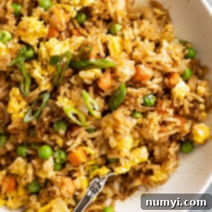 Close up of fried rice with a fork in the rice.