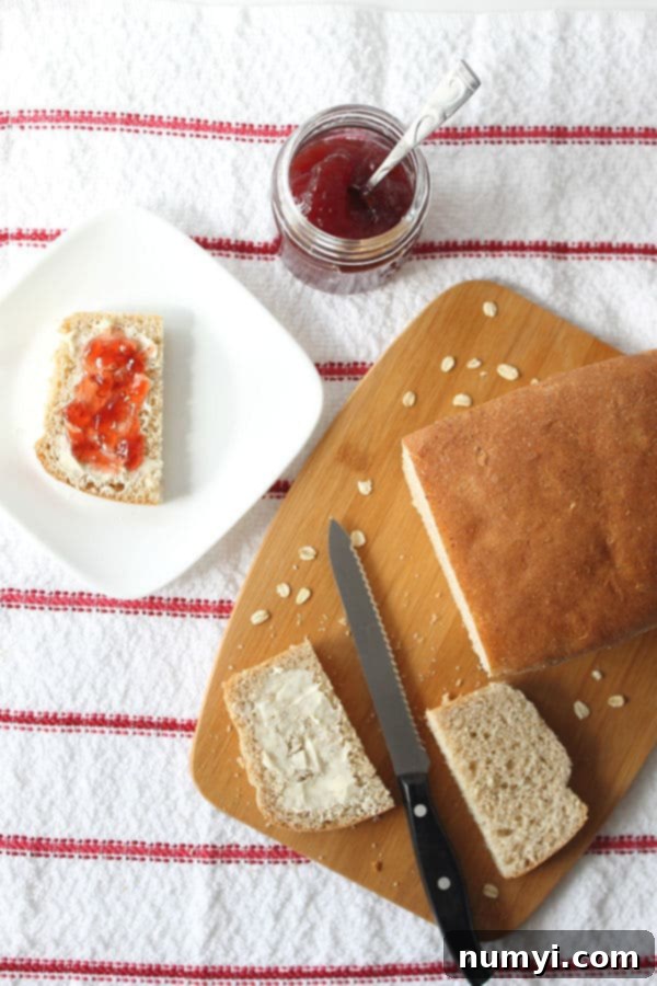 Wholesome Whole Wheat Oatmeal Bread 2 Whole Wheat Oatmeal Bread cut into a couple slices with one on an individual plate slathered in butter and jam