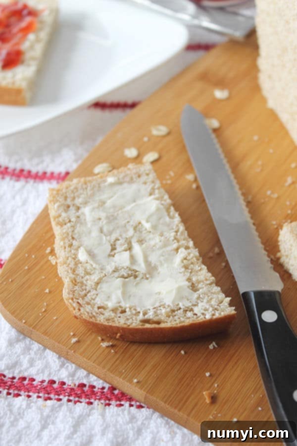 Wholesome Whole Wheat Oatmeal Bread 4 butter coated slice of Whole Wheat Oatmeal Bread next to a knife on the cutting board