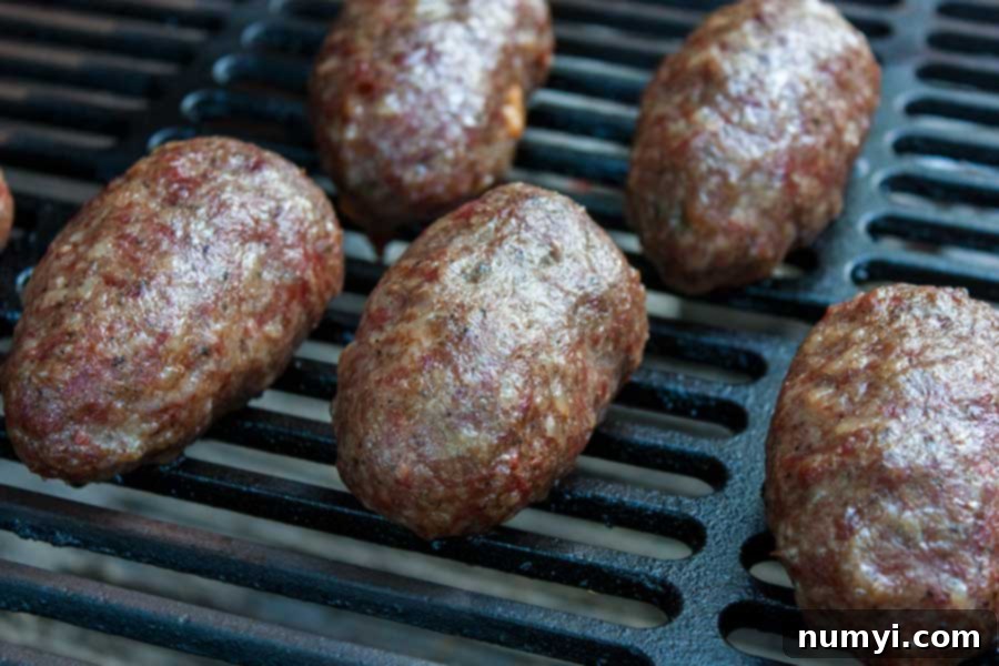 Ultimate Smoked Keto Armadillo Eggs 6 Keto armadillo eggs smoking on a grill, surrounded by fragrant wood smoke.