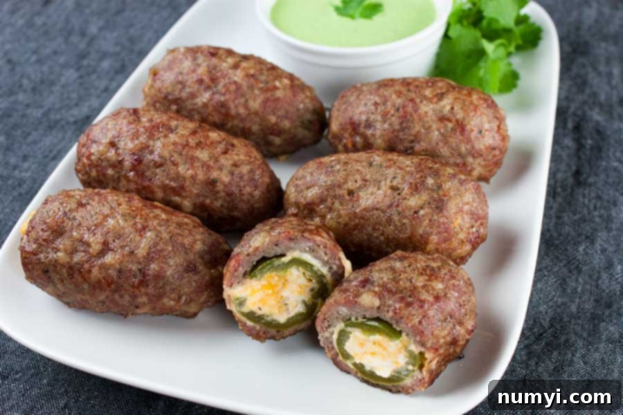Ultimate Smoked Keto Armadillo Eggs 7 Smoked Keto Armadillo Eggs arranged beautifully on a white platter with a side of Jalapeno Cilantro Dip.