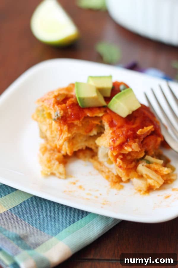 Individual serving of quick chicken enchilada bake topped with fresh avocado and sour cream