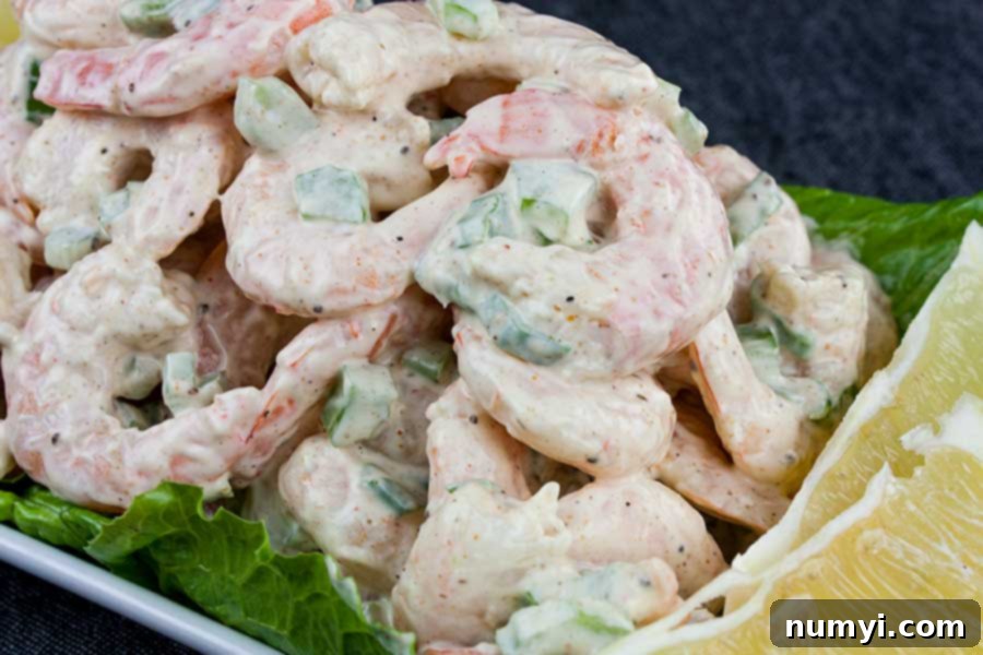 Easy Shrimp Salad 2 Shrimp Salad over lettuce leaves in a white bowl.