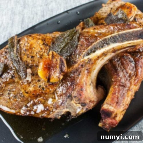 Thick cut bone in pork chops on a black plate, perfectly seared and juicy.