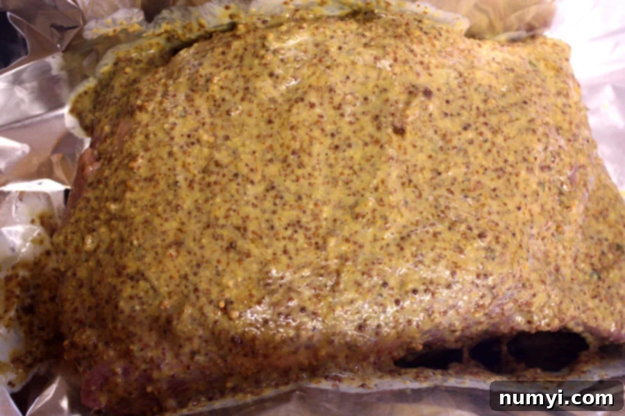 Corned Beef with the homemade mustard sauce spread over it, ready for baking.