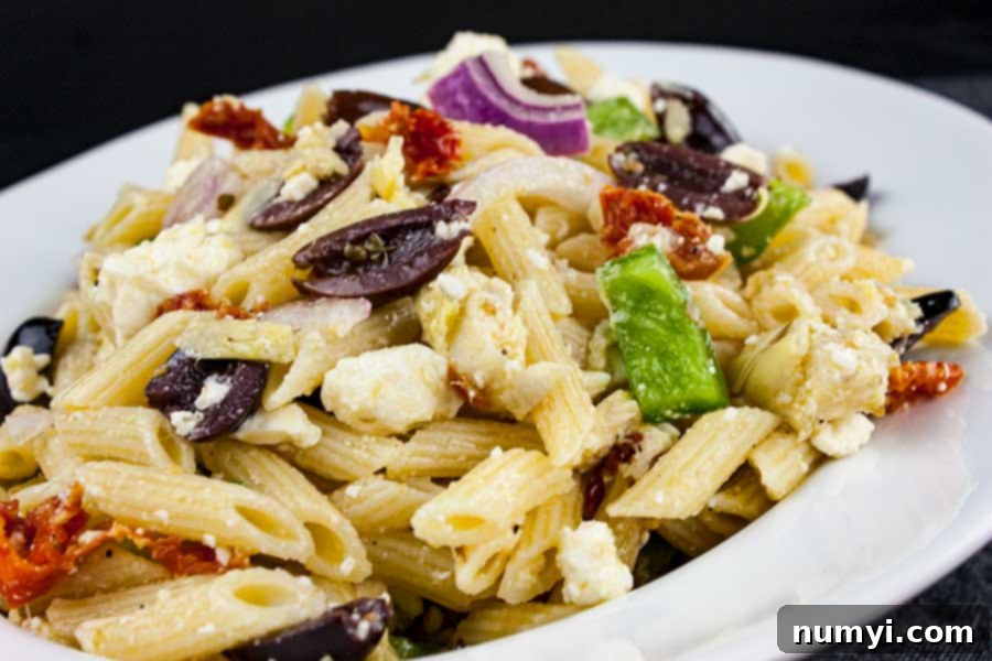 Zesty Greek Pasta Salad 5 A generously sized white bowl filled with freshly made Greek Pasta Salad, garnished with fresh herbs, ready for serving.