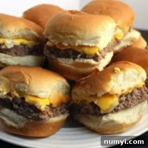 Ultimate Oven Cheeseburger Sliders 7 Oven Baked Sliders stacked up on a white plate, ready to be served and enjoyed.