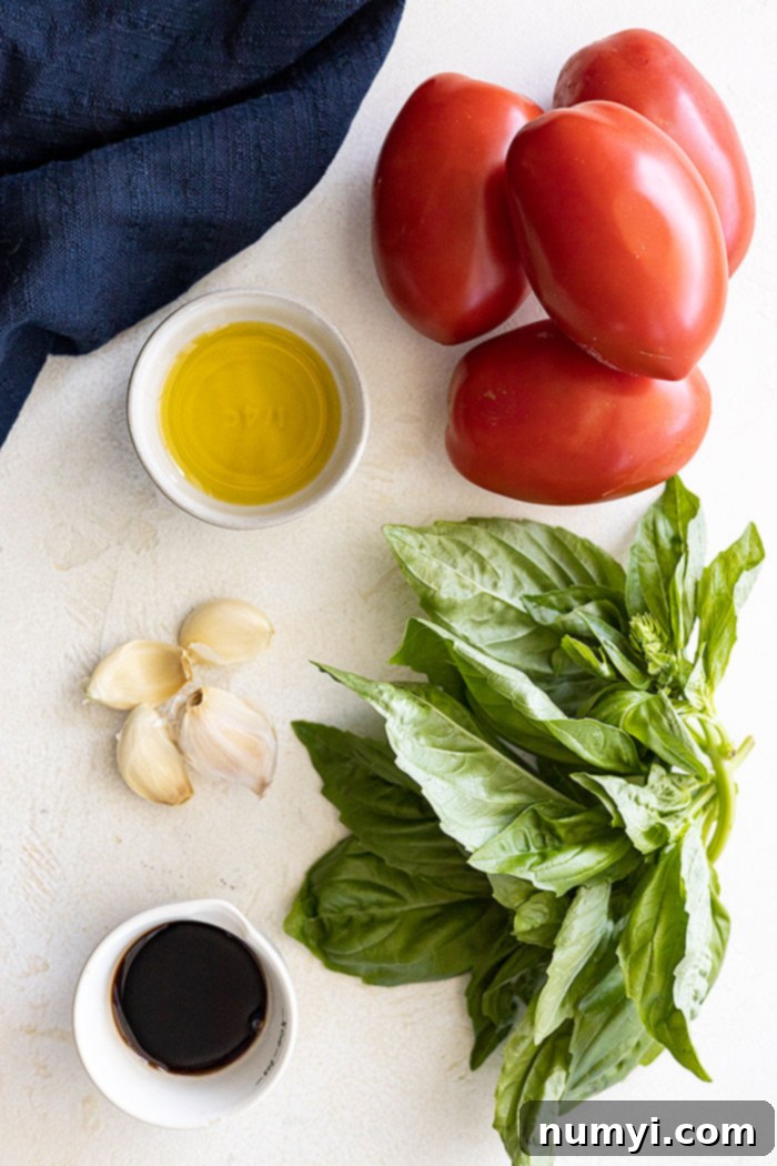 Bruschetta Made Simple 3 Collection of fresh ingredients arranged for making bruschetta: diced Roma tomatoes, vibrant green basil leaves, whole garlic cloves, a bottle of extra virgin olive oil, and balsamic vinegar.