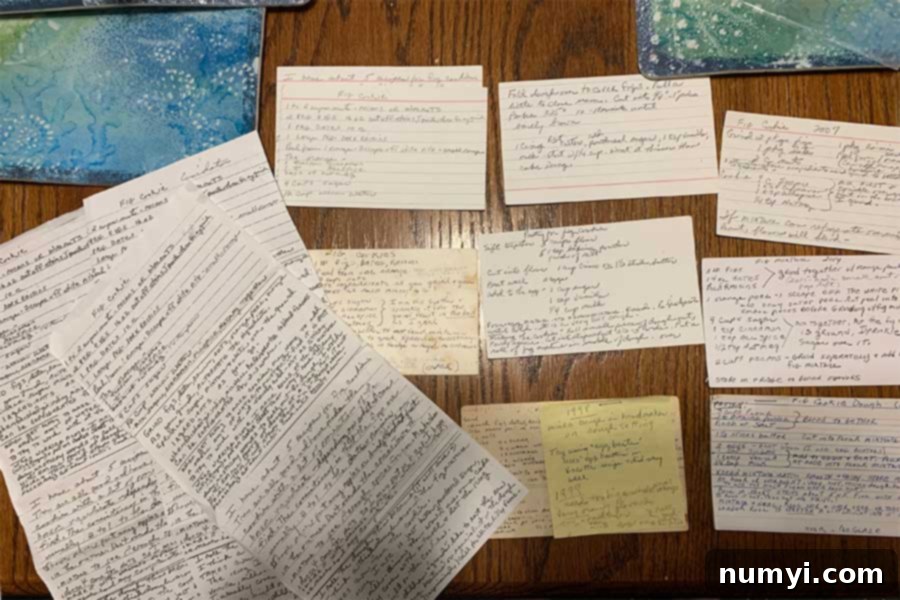 A collection of old, handwritten Cucidati recipes, some stained and worn, on a kitchen countertop.