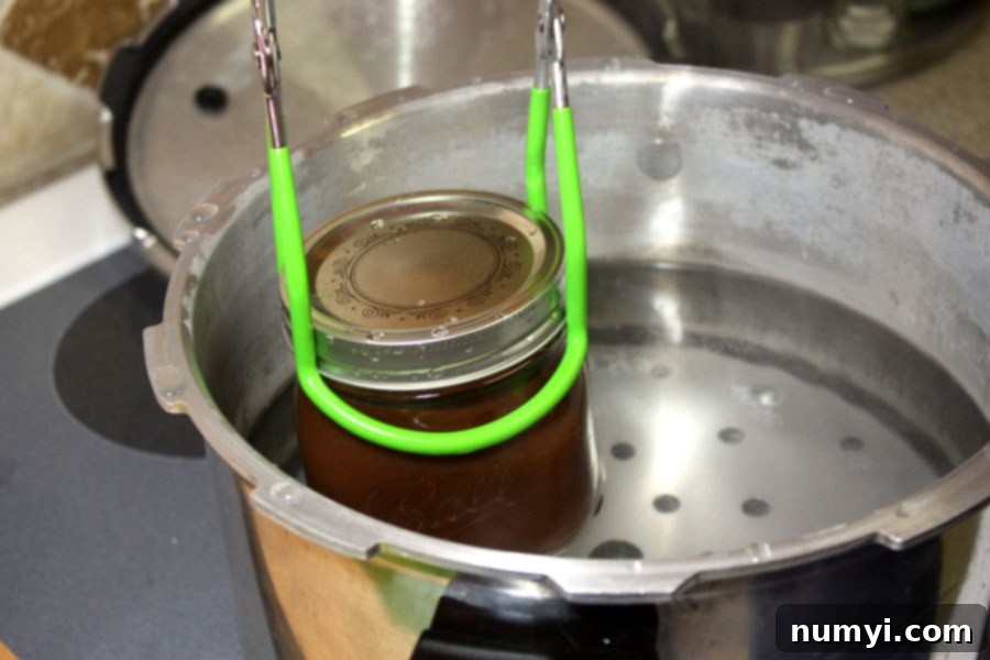 Mason jar being placed into a pressure cooker.