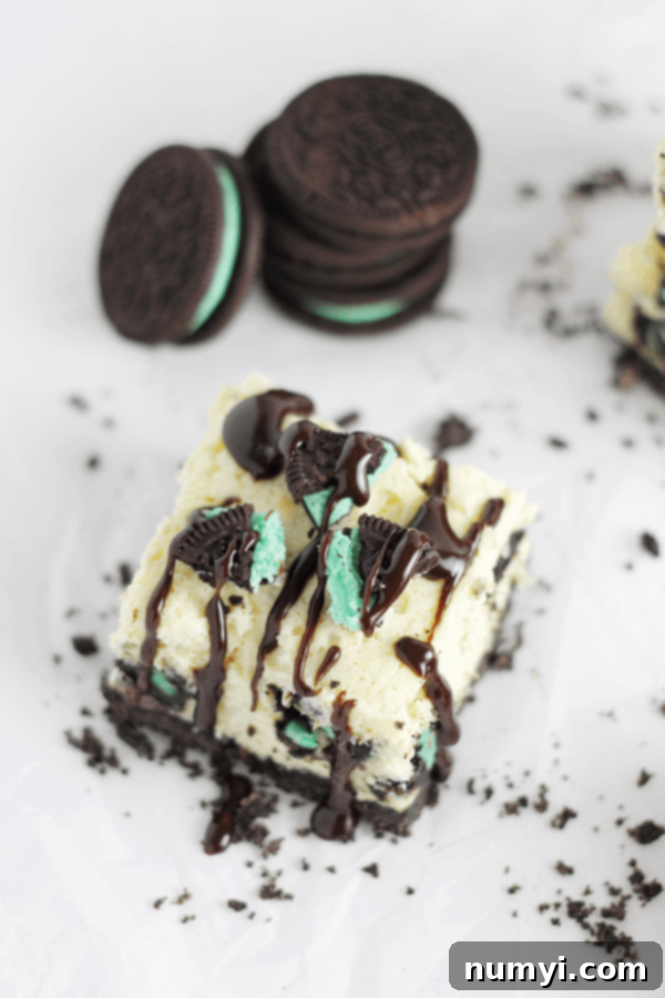 Close-up of a Mint Oreo Cheesecake Bar drizzled with luscious hot fudge sauce