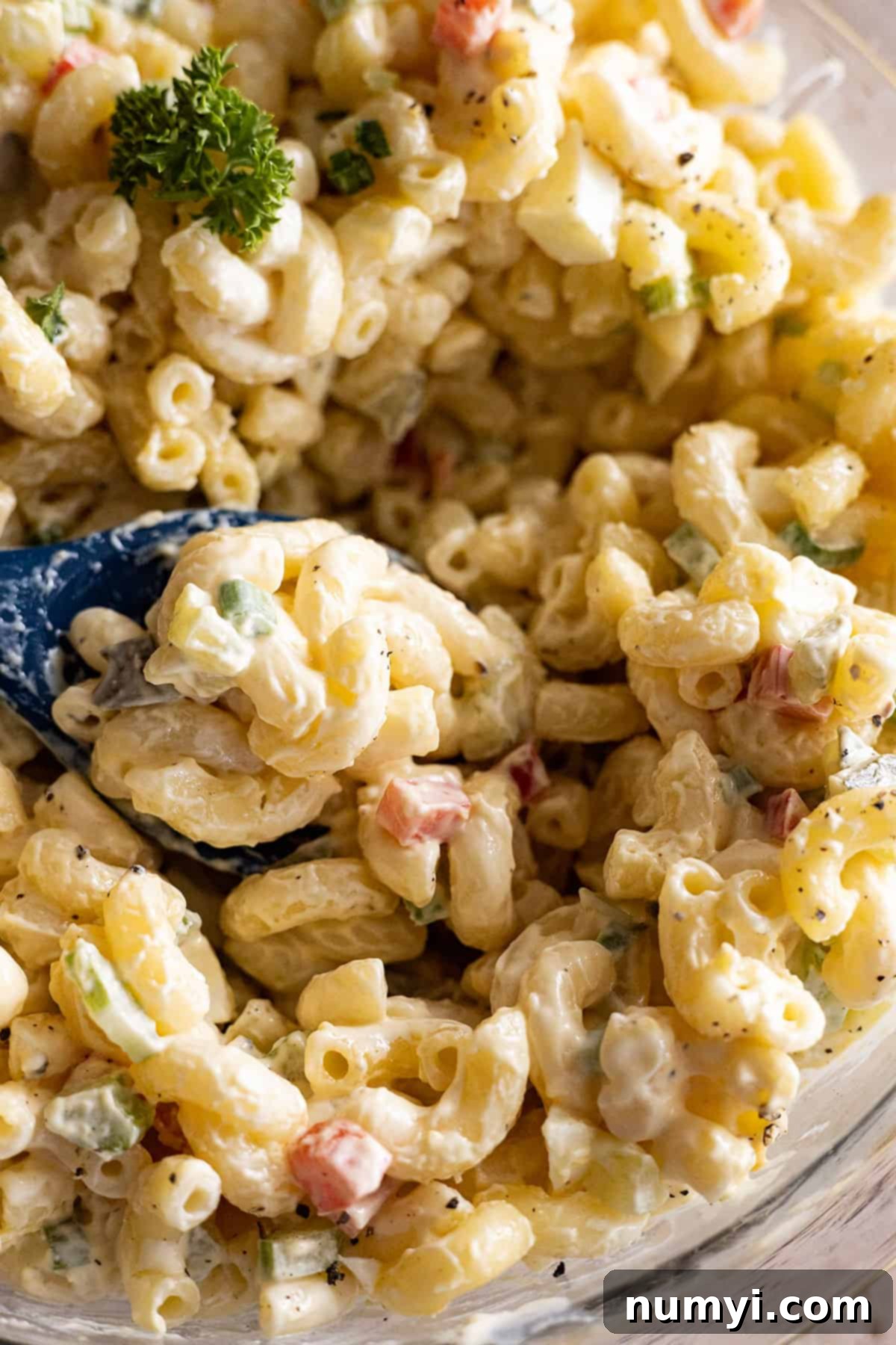 Macaroni salad with a spoon getting ready to take out a scoop, 
