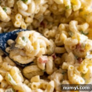 Macaroni salad with a spoon getting ready to take out a scoop,