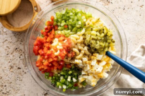 Overhead view of adding in remaining ingredients to toss in the dressing.