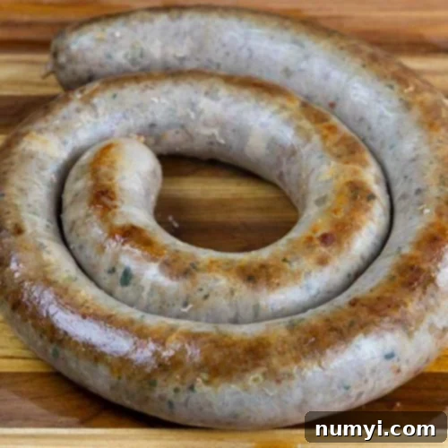 Authentic Homemade Fennel Italian Sausage Recipe 11 Cooked Italian sausage ring on a wooden cutting board, ready for serving.