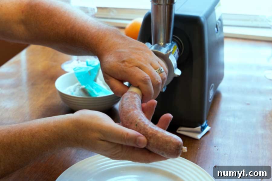 Authentic Homemade Fennel Italian Sausage Recipe 8 Italian sausage being expertly stuffed into a casing with a sausage stuffer.