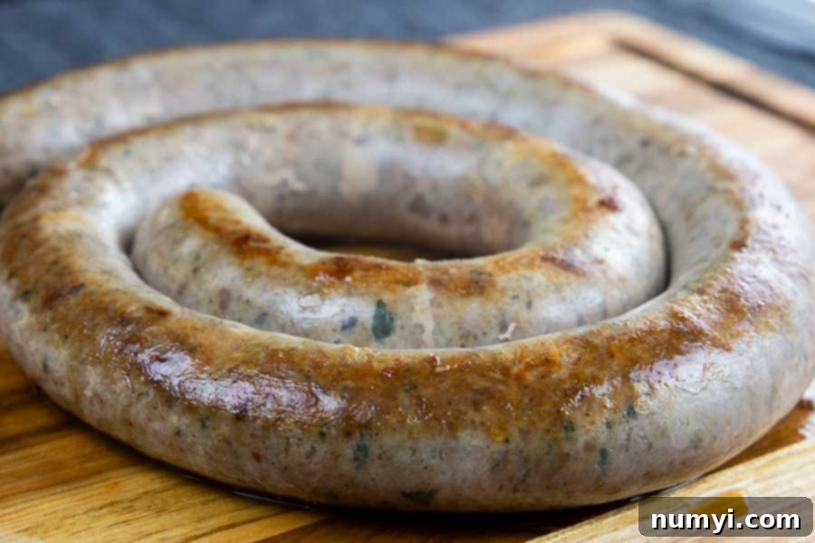 Authentic Homemade Fennel Italian Sausage Recipe 10 A perfectly cooked homemade Italian sausage ring on a rustic wooden cutting board.