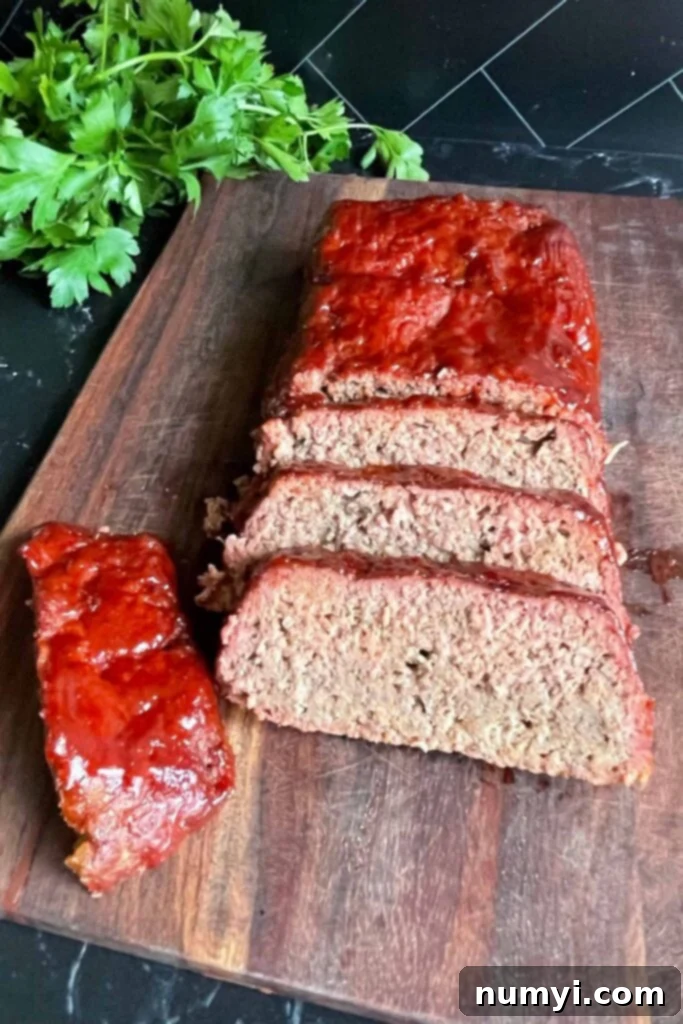 Smoky Meatloaf Perfection 12 Multiple slices of smoked meatloaf arranged neatly on a wooden cutting board.