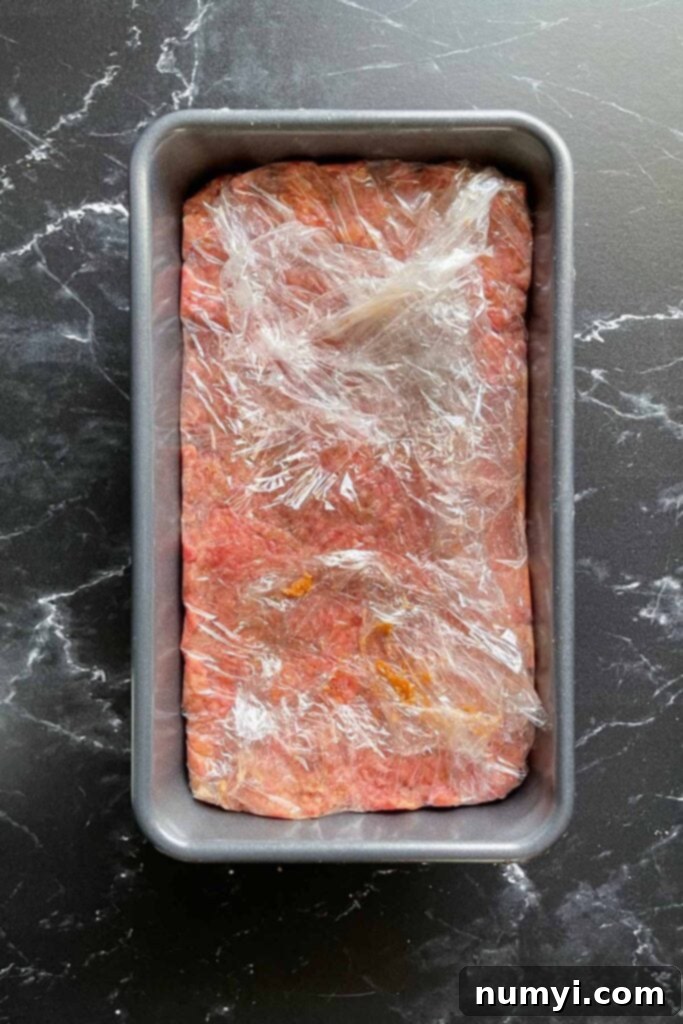 Smoky Meatloaf Perfection 7 Uncooked meatloaf firmly pressed into a loaf pan, ready for chilling.