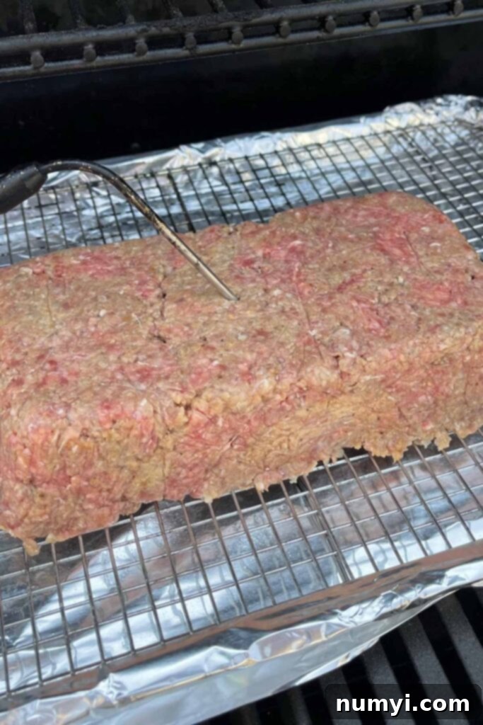 Smoky Meatloaf Perfection 9 Uncooked smoked meatloaf sitting in the smoker with a temperature probe inserted.