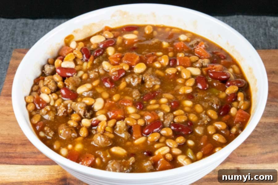A vibrant mix of three types of canned beans in a white bowl, ready for combining.