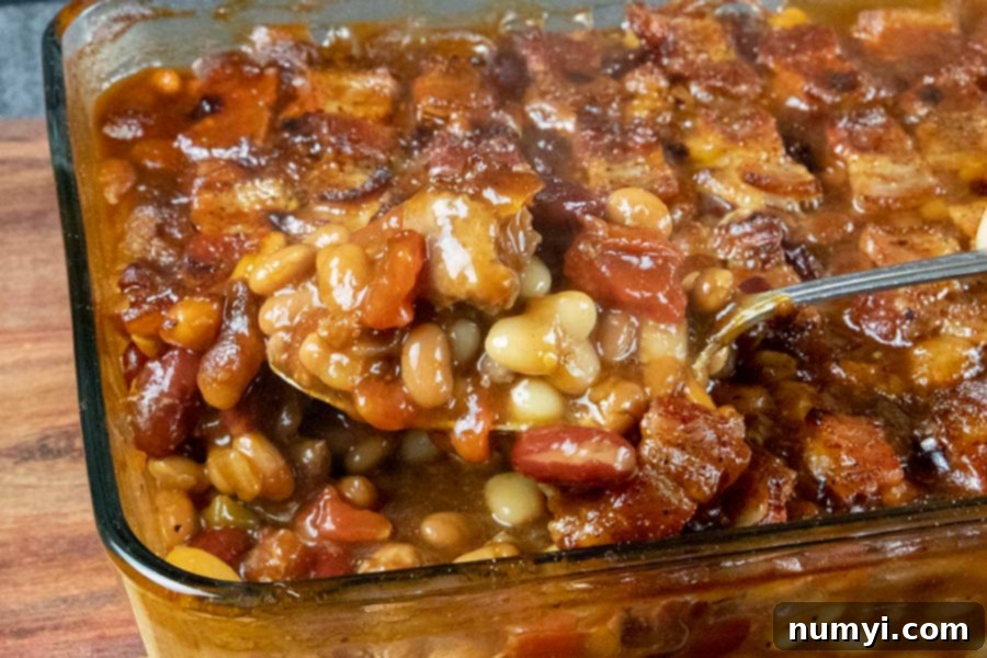 Deliciously bubbling, freshly baked beans with crispy bacon in a casserole dish, straight from the oven.