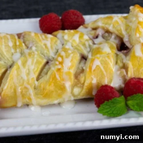 Decadent Raspberry Cream Cheese Danish 8 Raspberry cream cheese danish on a white platter garnished with fresh raspberries and mint.