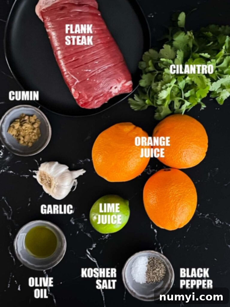 Fresh ingredients for grilled flank steak street tacos, including cilantro, garlic, limes, oranges, and a cut of steak.