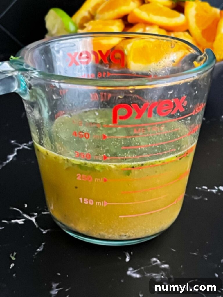 Vibrant marinade mixture in a glass measuring cup, ready for the steak.