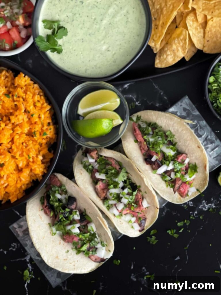 A perfectly assembled flank steak street taco, garnished with fresh cilantro and onions, ready to be served.