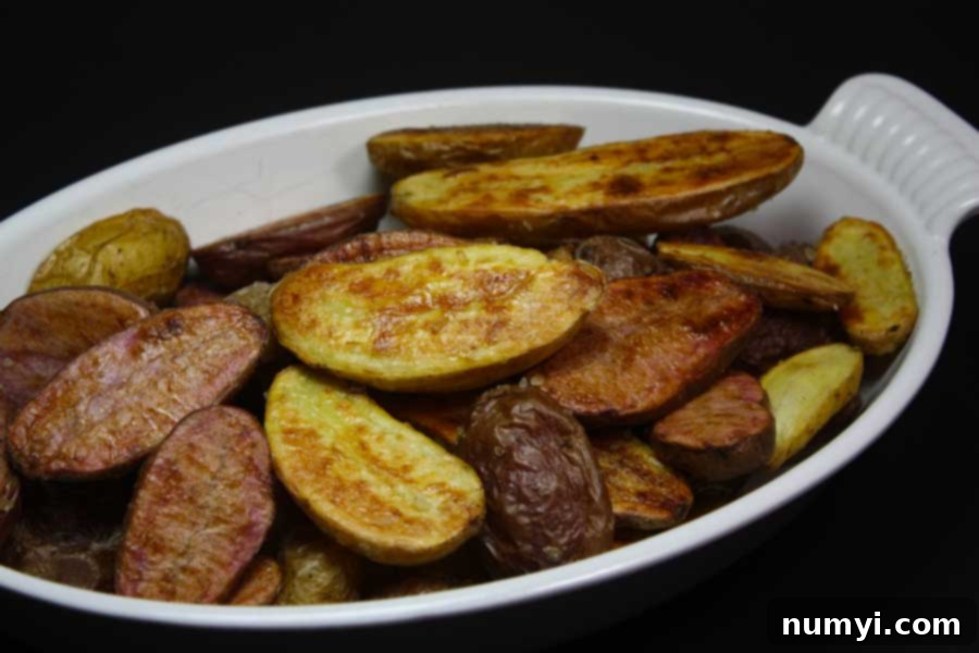 Roasted fingerling potatoes in a white serving dish, perfectly golden and crispy.