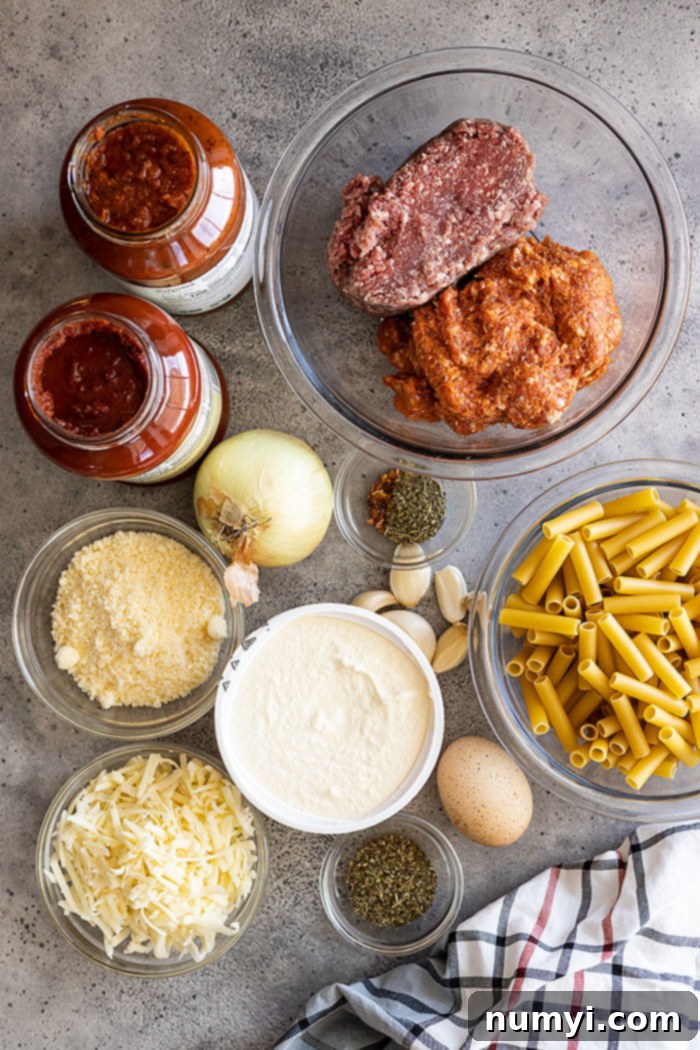Key ingredients for this flavorful baked ziti: ground beef, Italian sausage, ricotta cheese, mozzarella cheese, Parmesan cheese, fresh herbs, and marinara sauce.