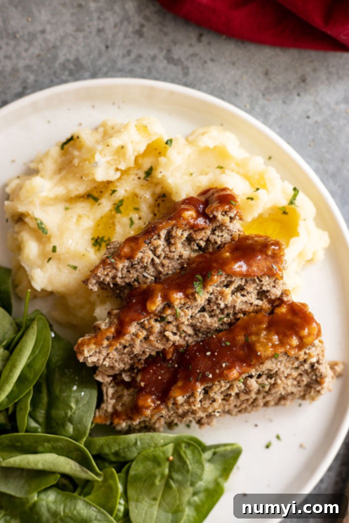 Delicious Instant Pot Meatloaf and creamy mashed potatoes served on a white plate, garnished with fresh parsley and black pepper, ready to be enjoyed.