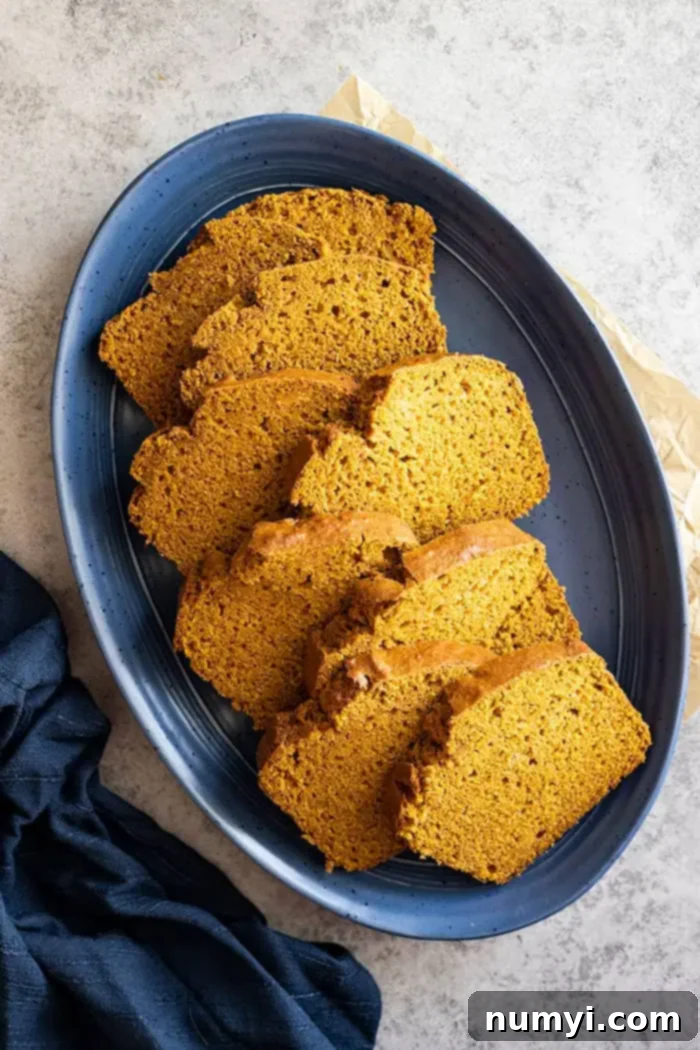 overhead: several slices of pumpkin pie spice bread staggered on a blue plate