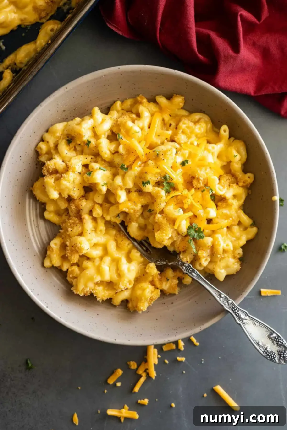 Overhead of mac and cheese in a bowl garnished with pepper and parsley.