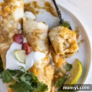 Overhead view of enchiladas on a plate with a fork taking a bite out.