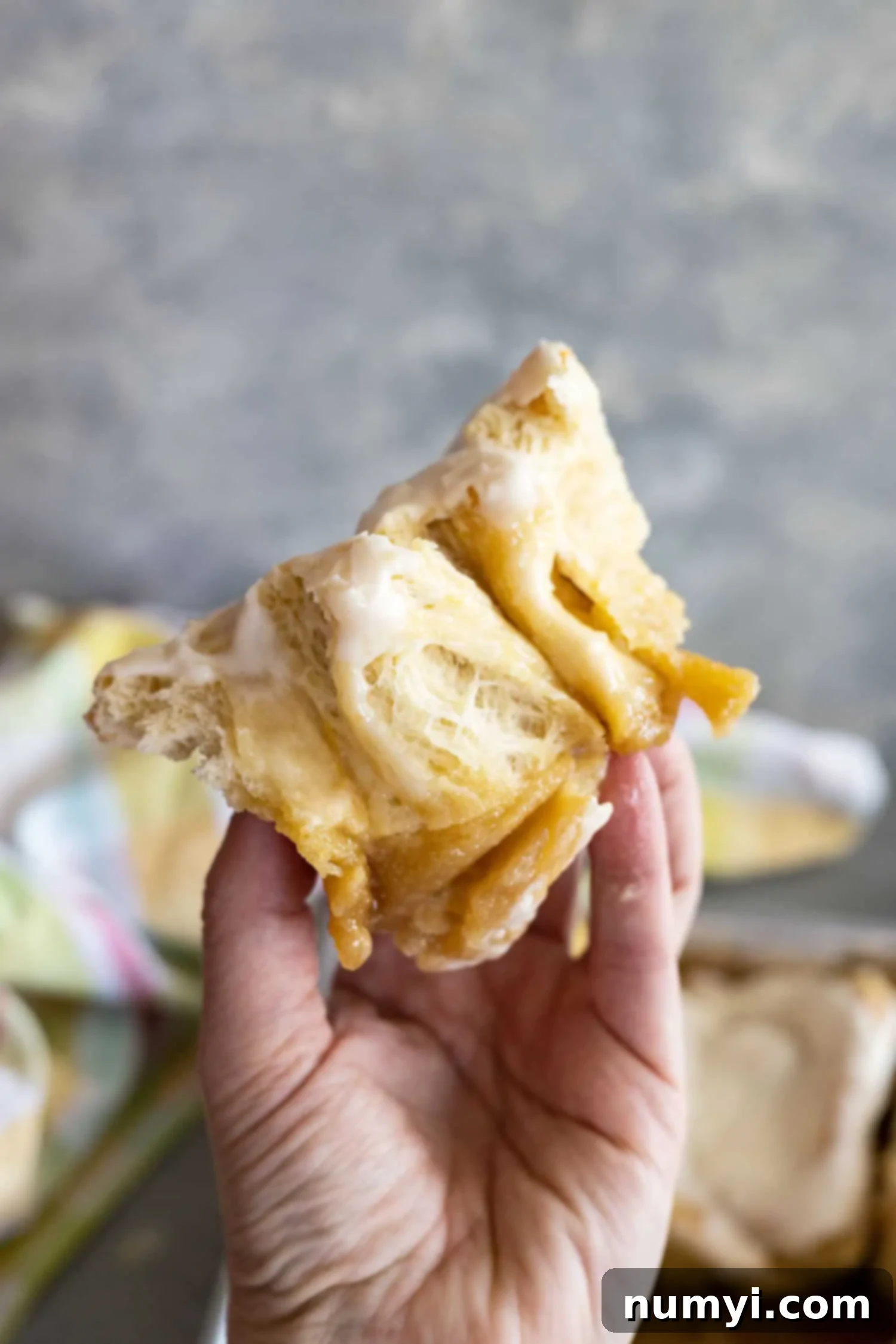 A hand holding up a roll cut in half to show the yummy fluffy interior. 