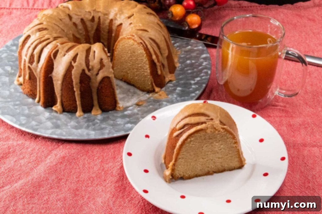 A single slice of apple cider pound cake perfectly plated on a white dish, ready to be enjoyed.