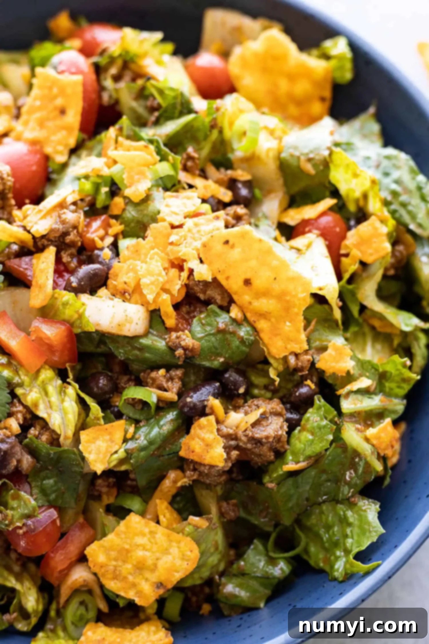 Close up of dorito taco salad in a blue bowl. 