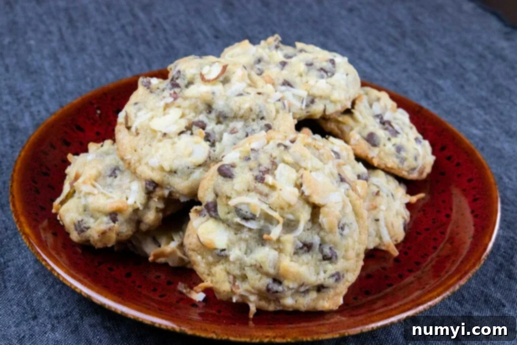 Almond joy cookies on red plate, perfectly golden brown with visible coconut, chocolate, and almonds.