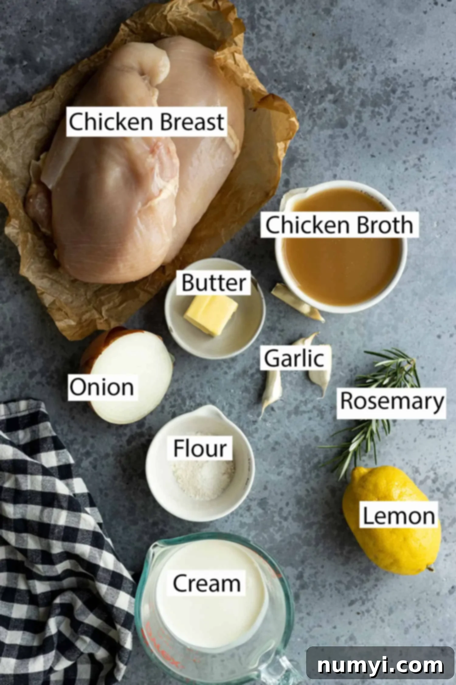 Ingredients for creamy lemon chicken: boneless skinless chicken breasts, chicken broth, butter, diced onion, minced garlic, fresh rosemary, fresh lemon, all-purpose flour, and heavy cream.