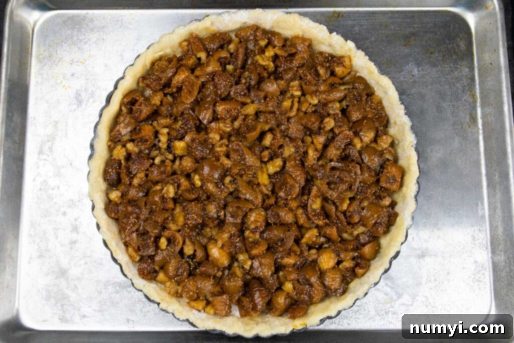 Assembled fig tart pastry on a baking sheet, ready for the oven.