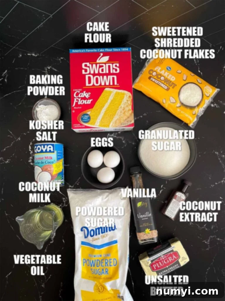 A collection of fresh, high-quality ingredients for a homemade coconut cake, neatly arranged on a dark kitchen surface, awaiting preparation.