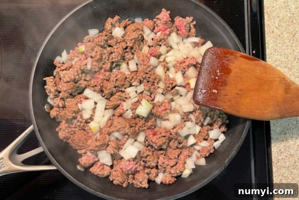 Ground beef and onion browning in a skillet