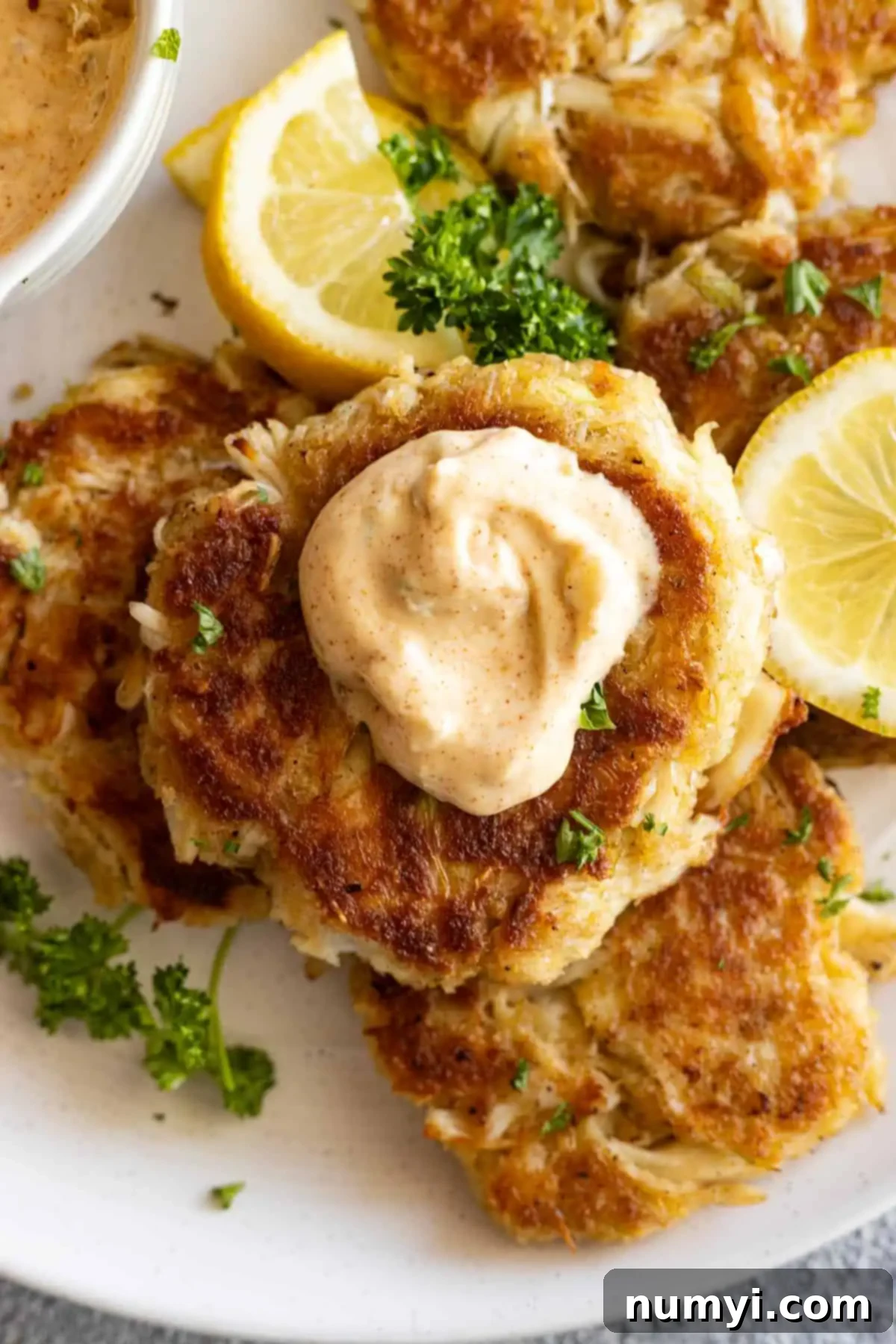 Simply Perfect Crab Cakes 6 Crab cake with a dollop of sauce on top.