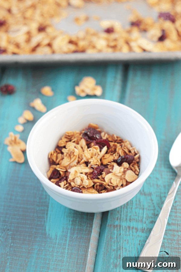 a bowl of our maple almond granola recipe in a white bowl on a blue table