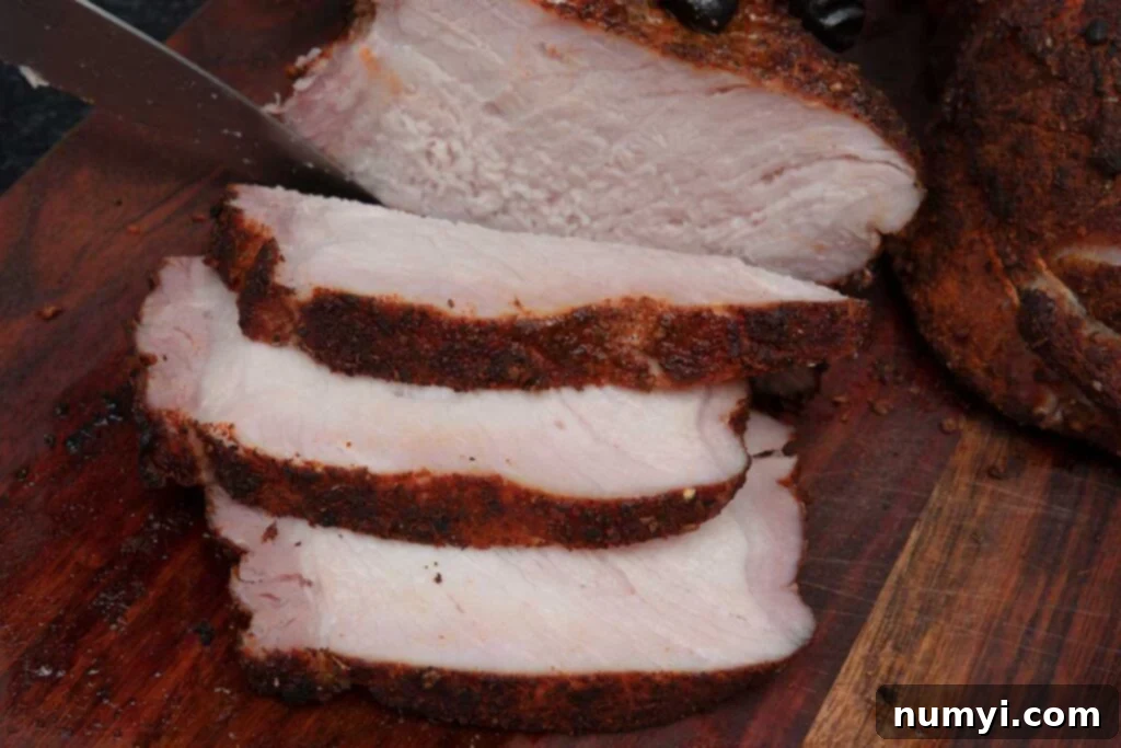 Smoked Porterhouse Pork Chops 9 Beautifully sliced double bone-in smoked pork chops revealing their tender, juicy interior on a cutting board.