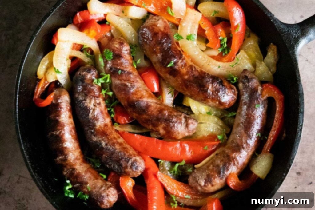 Sizzling Beer Brats with Peppers and Onions 2 Beer brats with peppers and onions in a cast iron skillet.