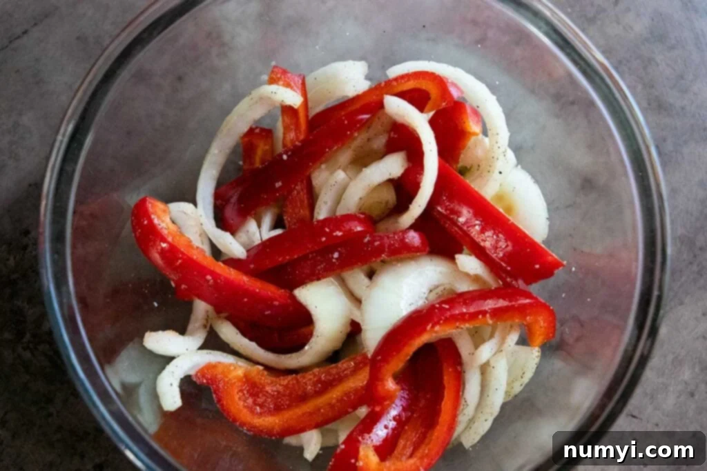 Sizzling Beer Brats with Peppers and Onions 4 Onions and red peppers cut in a glass bowl